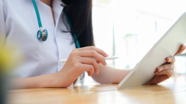 Bilgisayarı kullanırken tıbbi raporları inceleyen doktoru kapat.