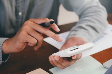 Ekonomi Tasarruf Fonu konsepti. Erkek muhasebeci veya bankacı hesap makinesi kullanır.