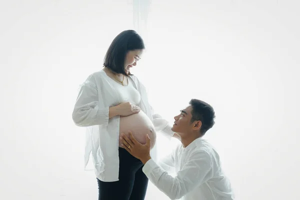 Pregnant woman with husband. Family, pregnancy and parenthood concept.