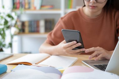 Cep telefonu kullanan genç bir kadın. İş, eğitim ve iletişim için çevrimiçi bağlantı teknolojisi kullanılıyor. 