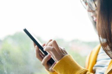 Genç adam cep telefonu kullanıyor. İş, eğitim ve iletişim için çevrimiçi bağlantı teknolojisi kullanılıyor. 