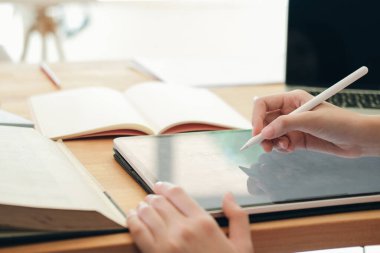 İnternette bilgisayar ve dijital tablet kullanan genç bir kolaj öğrencisi. Eğitim ve çevrimiçi öğrenim.