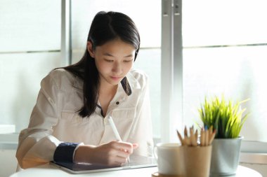 Bilgisayar ve mobil cihaz kullanan genç bir kolaj öğrencisi. Eğitim ve çevrimiçi öğrenim. 