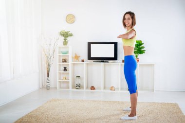 Genç fitness kadının yapması önünde oturma odasında Tv egzersizleri