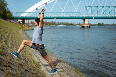 Erkek atlet yapıyor egzersiz germe ve sabah egzersiz için hazırlanıyor