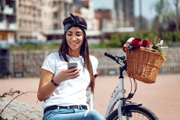 Ung Kvinna Med Cykel Med Blomsterkorg Med Smartphone — Stockfoto