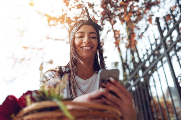 Ung Kvinna Med Cykel Med Blomsterkorg Med Smartphone — Stockfoto