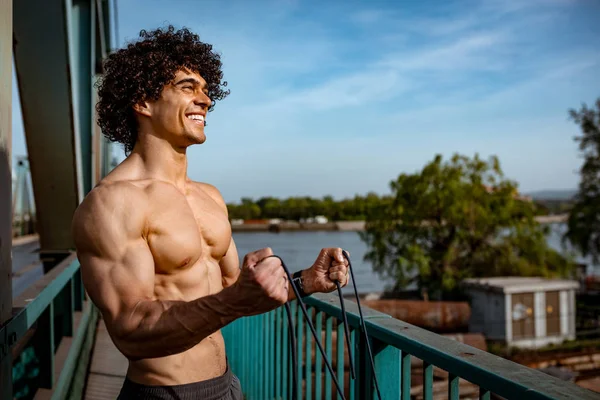 裸の胴体と弾性ゴムバンド運動を行うと筋肉の若い男 — ストック写真