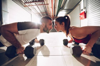 Push-up yapıyor genç kas çift Dambıl ile zor egzersiz spor salonunda egzersiz