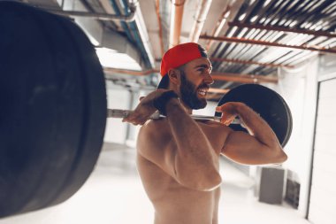 Genç kaslı adam yüksek çekme egzersiz halter ile çapraz eğitim saatinde