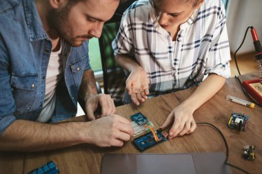 İki genç iş ortakları teknisyen elektronik donatımın tamiri üzerinde duruldu