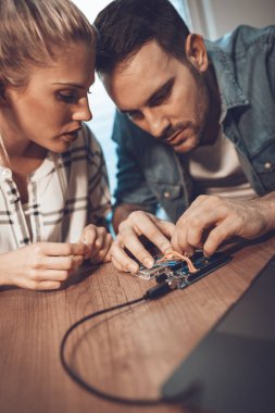 İki genç iş ortakları teknisyen elektronik donatımın tamiri üzerinde duruldu