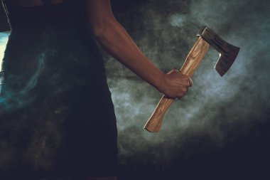 Dumanlı karanlık odada balta tutan kadın görünümü Kapat 