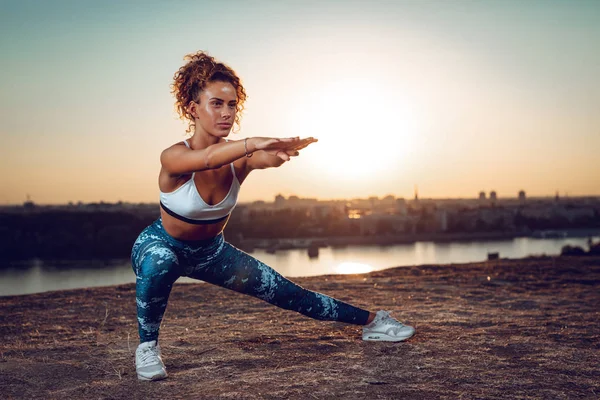 Jovem Mulher Esportiva Fazendo Exercícios Alongamento Pelo Rio Pôr Sol — Fotografia de Stock