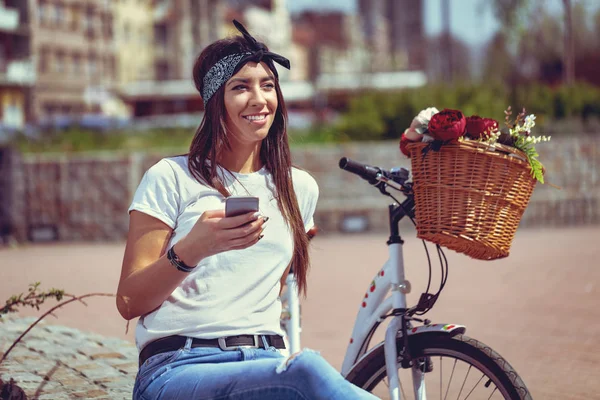 Młoda Kobieta Rowerów Kosz Kwiatów Pomocą Smartfona — Zdjęcie stockowe