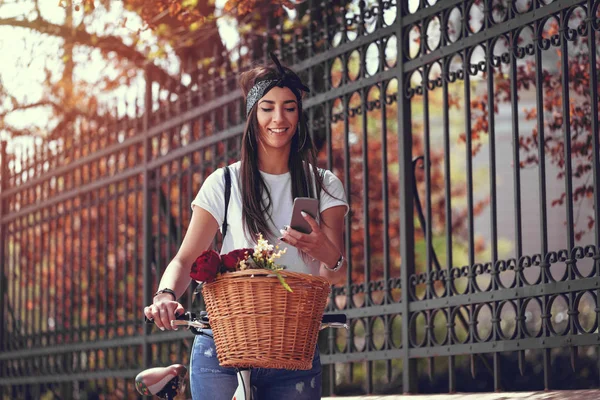 Jovem Com Bicicleta Com Cesta Flores Usando Smartphone — Fotografia de Stock