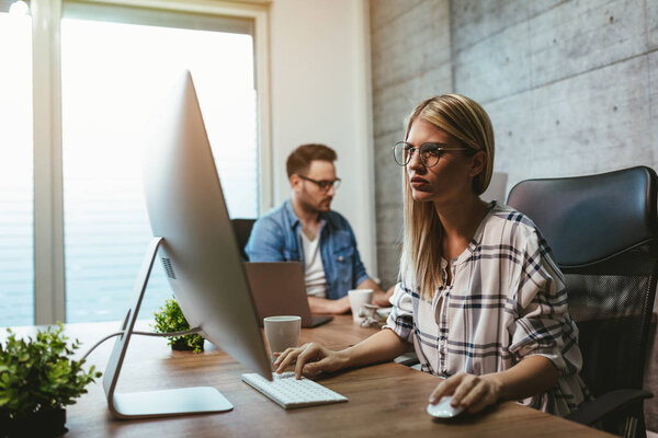 Young successful businesswoman and businessman working in office