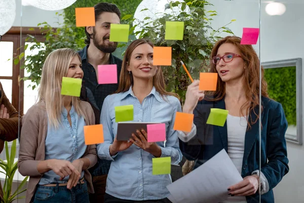 Kollegen Stehen Und Diskutieren Büro Hinter Glaswand Mit Klebrigen Zetteln — Stockfoto