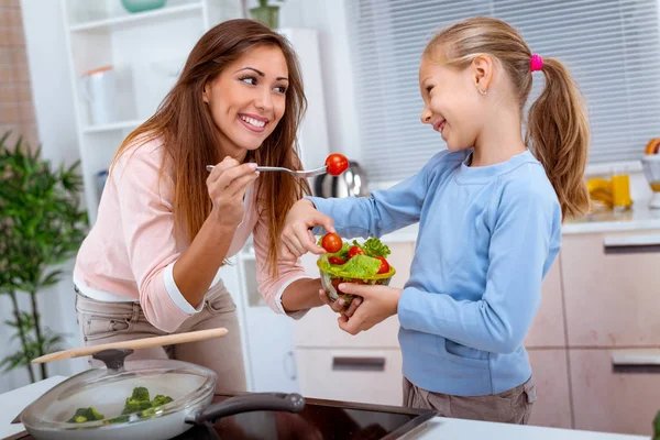 母亲和女儿一起烹调健康膳食在厨房里 — 图库照片