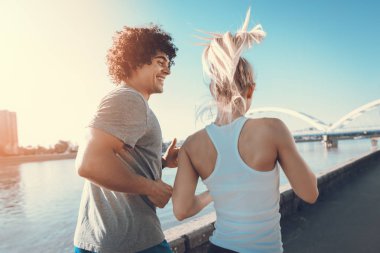 Genç çift dışında nehir kenarında güneş doğarken koşu