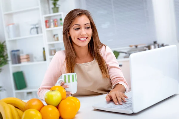 Young Woman Drinking Coffee Reading Recipe Laptop Kitchen — Stock Photo, Image