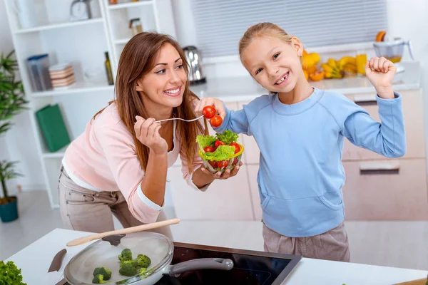 母亲和女儿一起烹调健康膳食在厨房里 — 图库照片