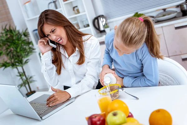 Niña Desayunando Mientras Madre Sobrecargada Trabajo Telefonea Comprueba Información Portátil —  Fotos de Stock