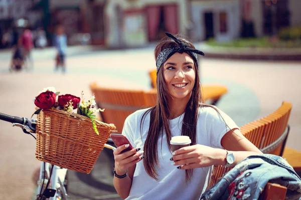 Bisiklet Smartphone Kullanarak Kahve Içme Çiçek Sepeti Ile Olan Kadın — Stok fotoğraf