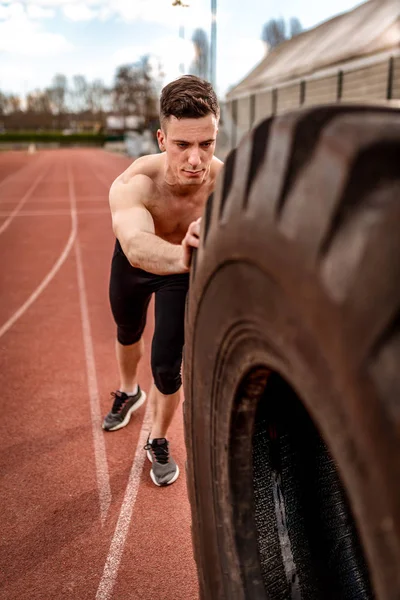 Hombre Musculoso Joven Levantando Neumático Enorme Para Los Músculos Entrenamiento —  Fotos de Stock