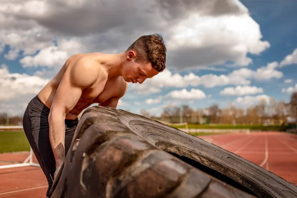 Hombre Musculoso Joven Levantando Neumático Enorme Para Los Músculos Entrenamiento —  Fotos de Stock