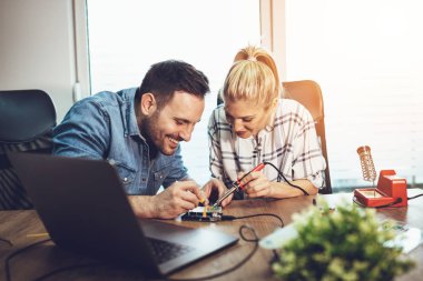 İki genç iş ortakları teknisyen elektronik donatımın tamiri üzerinde duruldu