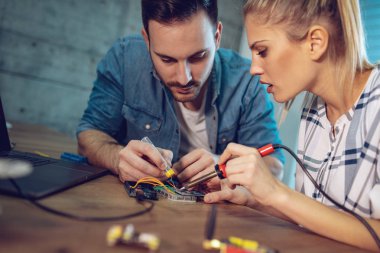 İki genç iş ortakları teknisyen elektronik donatımın tamiri üzerinde duruldu