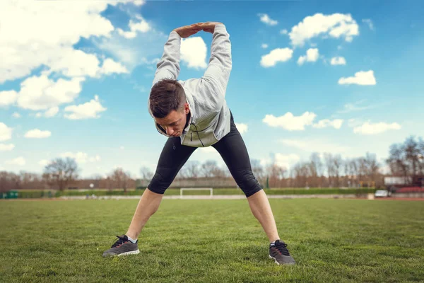 Hombre Joven Activo Estirando Cuerpo Antes Trotar Estadio Vacío —  Fotos de Stock