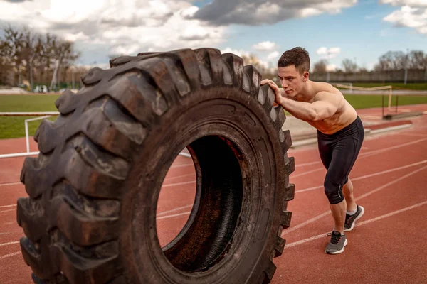 Hombre Musculoso Joven Levantando Neumático Enorme Para Los Músculos Entrenamiento —  Fotos de Stock