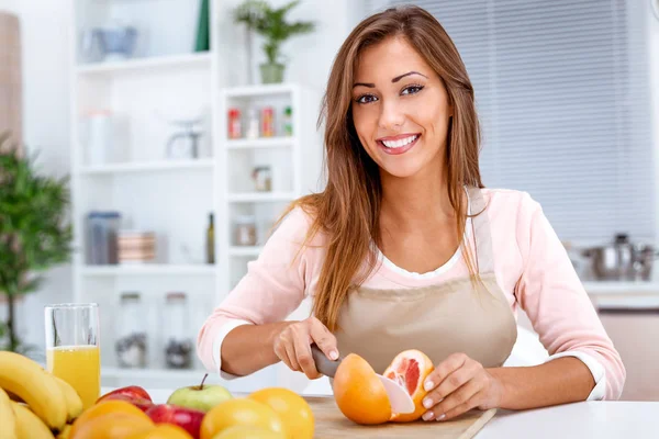 Jeune Femme Coupant Pamplemousse Rouge Sur Planche Cuisine — Photo