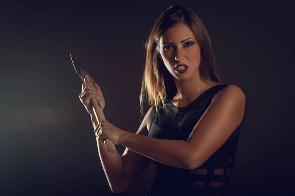 dangerous woman with rusty ax in dark smoky room