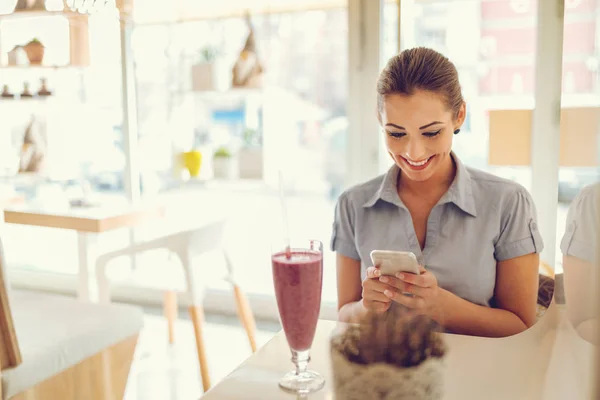 Jonge Glimlachende Zakenvrouw Met Behulp Van Smartphone Drinken Fruit Smoothie — Stockfoto