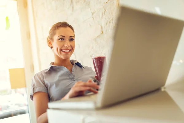 Jovem Mulher Negócios Sorrindo Trabalhando Laptop Bebendo Smoothie Frutas — Fotografia de Stock