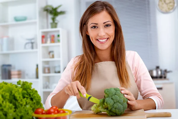 young woman preparing vegetarian food on kitchen table
