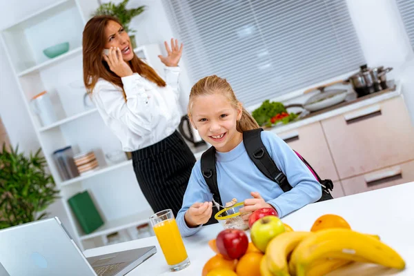 Niña Desayunando Mientras Madre Sobrecargada Trabajo Telefonea Comprueba Información Portátil — Foto de Stock