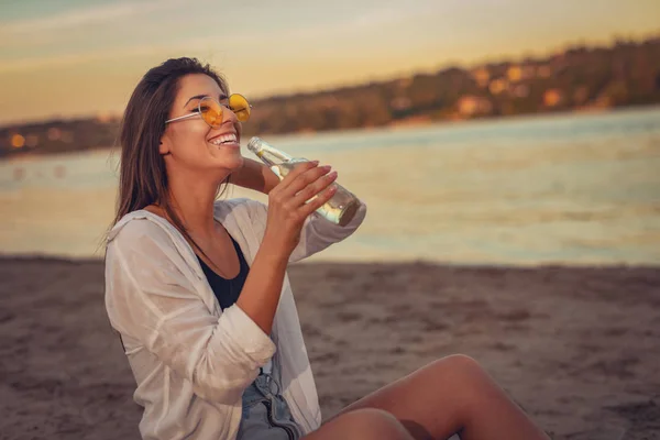 Jonge Vrouw Gele Sunglesses Bier Drinken Het Strand Bij Zonsondergang — Stockfoto