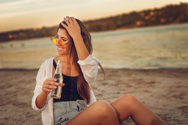 Jonge Vrouw Gele Sunglesses Bier Drinken Het Strand Bij Zonsondergang — Stockfoto