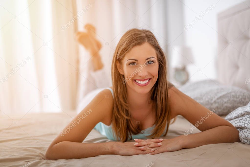 young smiling woman relaxing in morning in bedroom