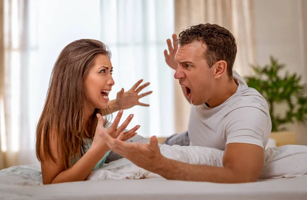 Angry couple having argument in bed