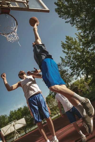 street basketball players playing on court in park