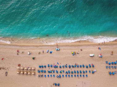 Renkli şemsiye ile şaşırtıcı pastoral plaj ve şezlong insanlarla havadan görünümü 