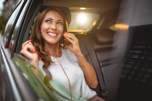 Młoda Kobieta Uśmiechający Się Rozmawia Smartfonie Siedząc Tylnym Siedzeniu Samochodzie — Zdjęcie stockowe