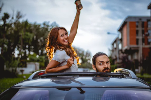 Jovem Casal Louco Divertindo Espreitando Através Teto Solar Durante Condução — Fotografia de Stock