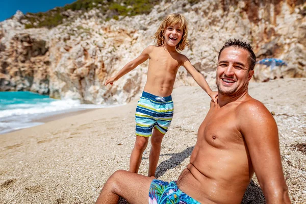 Schöner Kleiner Junge Mit Vater Sitzt Strand Und Schaut Die — Stockfoto