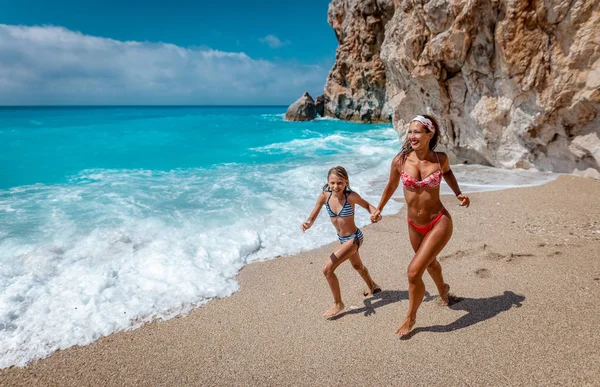 美しい少女の母親とビーチ 海岸の中を楽しんで — ストック写真